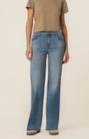 Person wearing light blue jeans and a beige shirt on a plain background