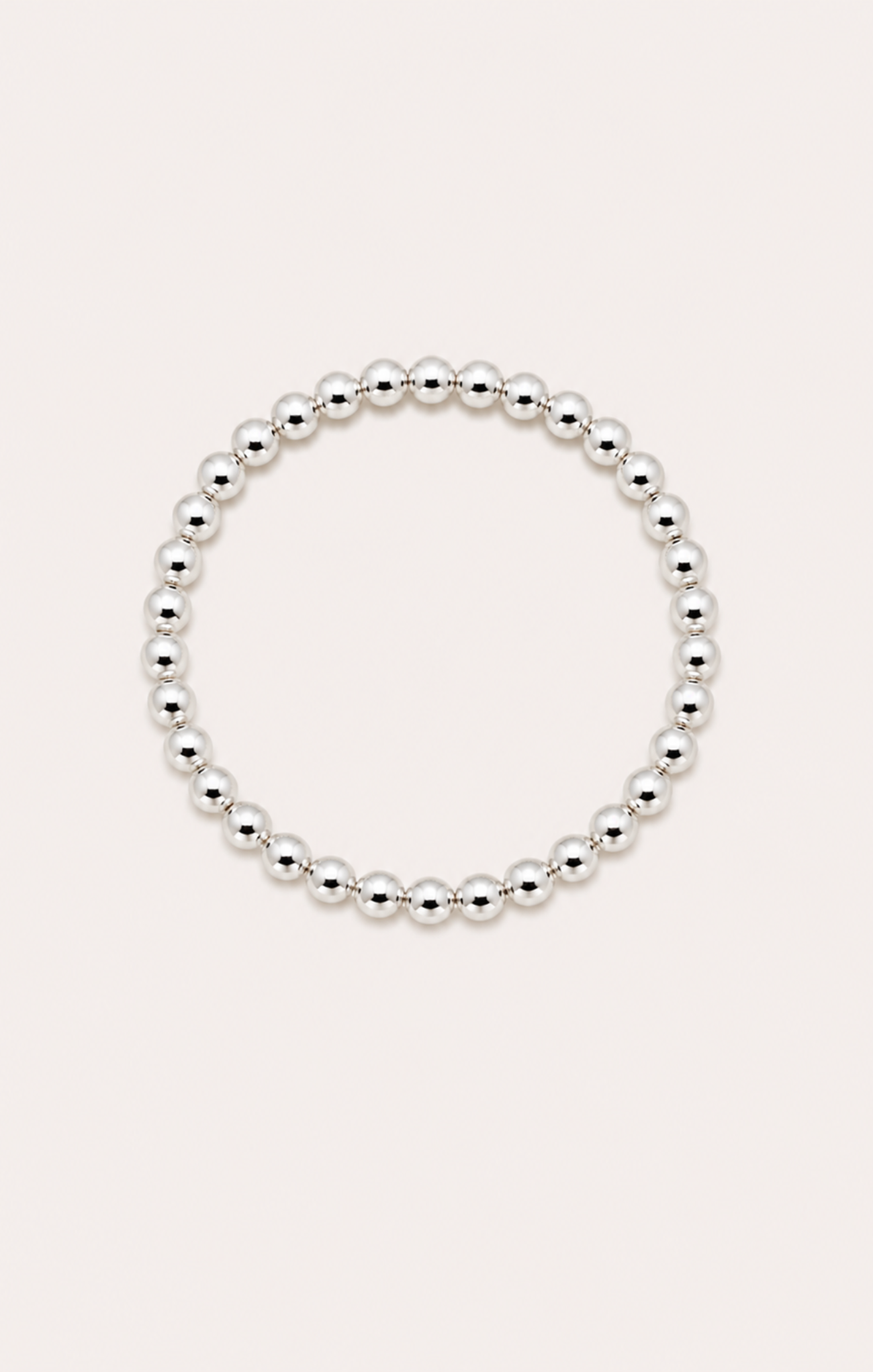 Silver beaded bracelet on a wrist with a beach background