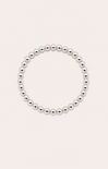 Silver beaded bracelet on a wrist with a beach background