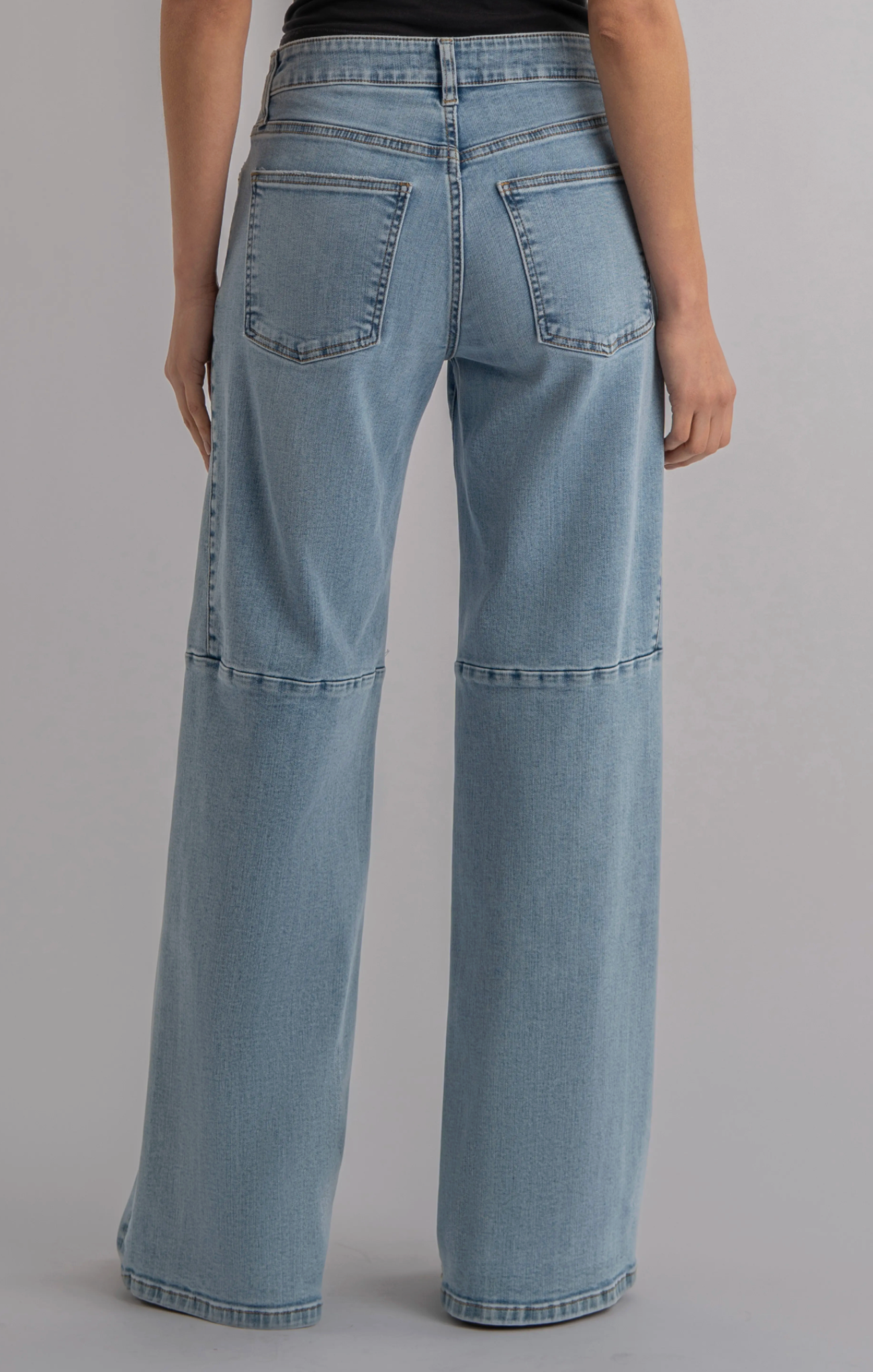 Light blue jeans worn by a person on a gray background