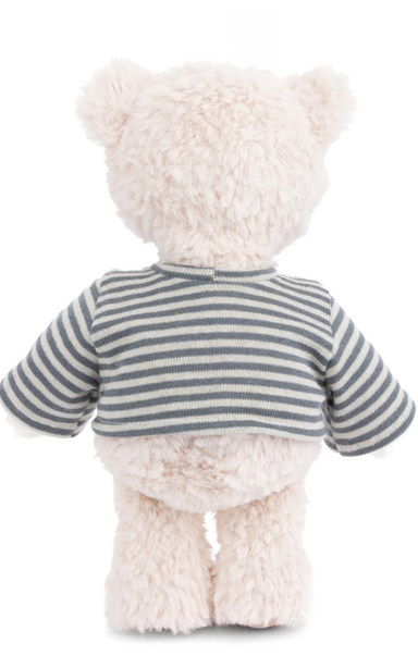 White teddy bear wearing a striped sweater on a white background