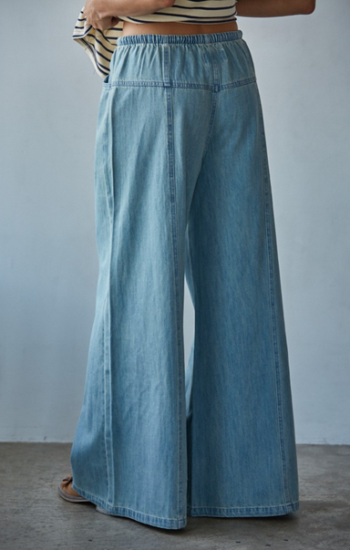 Light blue denim wide-leg pants worn by a person against a gray background