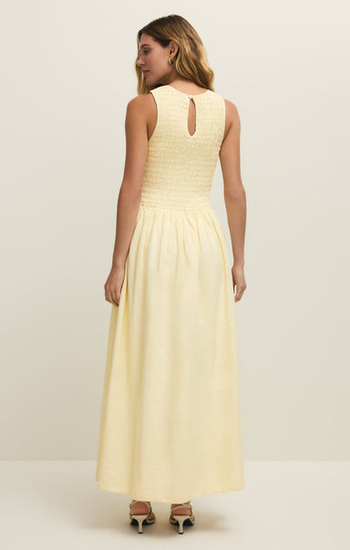 Woman wearing a light yellow dress against a white background