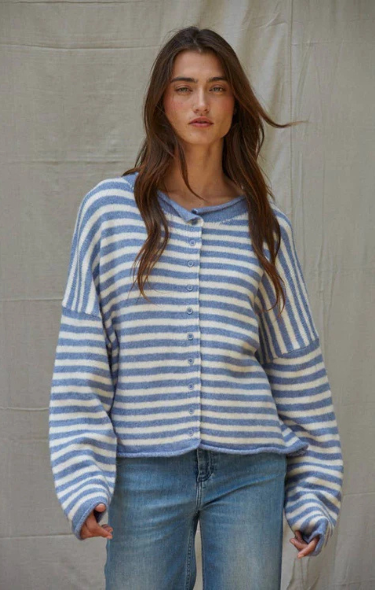 Woman wearing a blue and white striped sweater against a neutral background