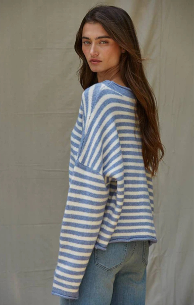 Woman wearing a blue and white striped sweater against a beige background