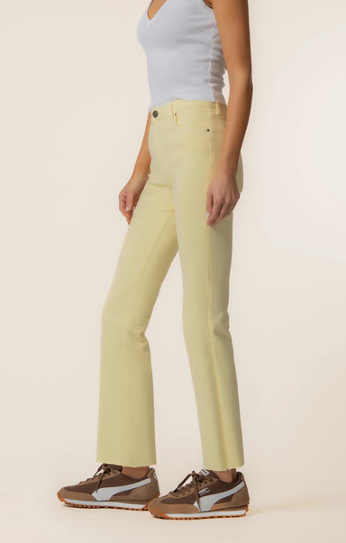 Person wearing light-colored pants and a light blue top on a plain background