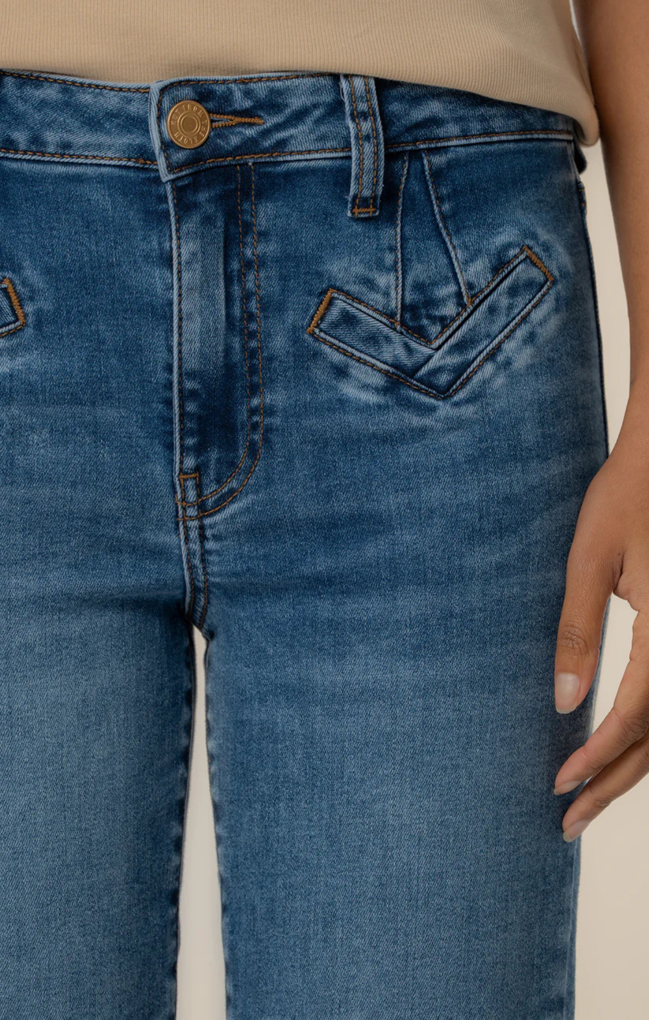Close-up of blue jeans with a beige background