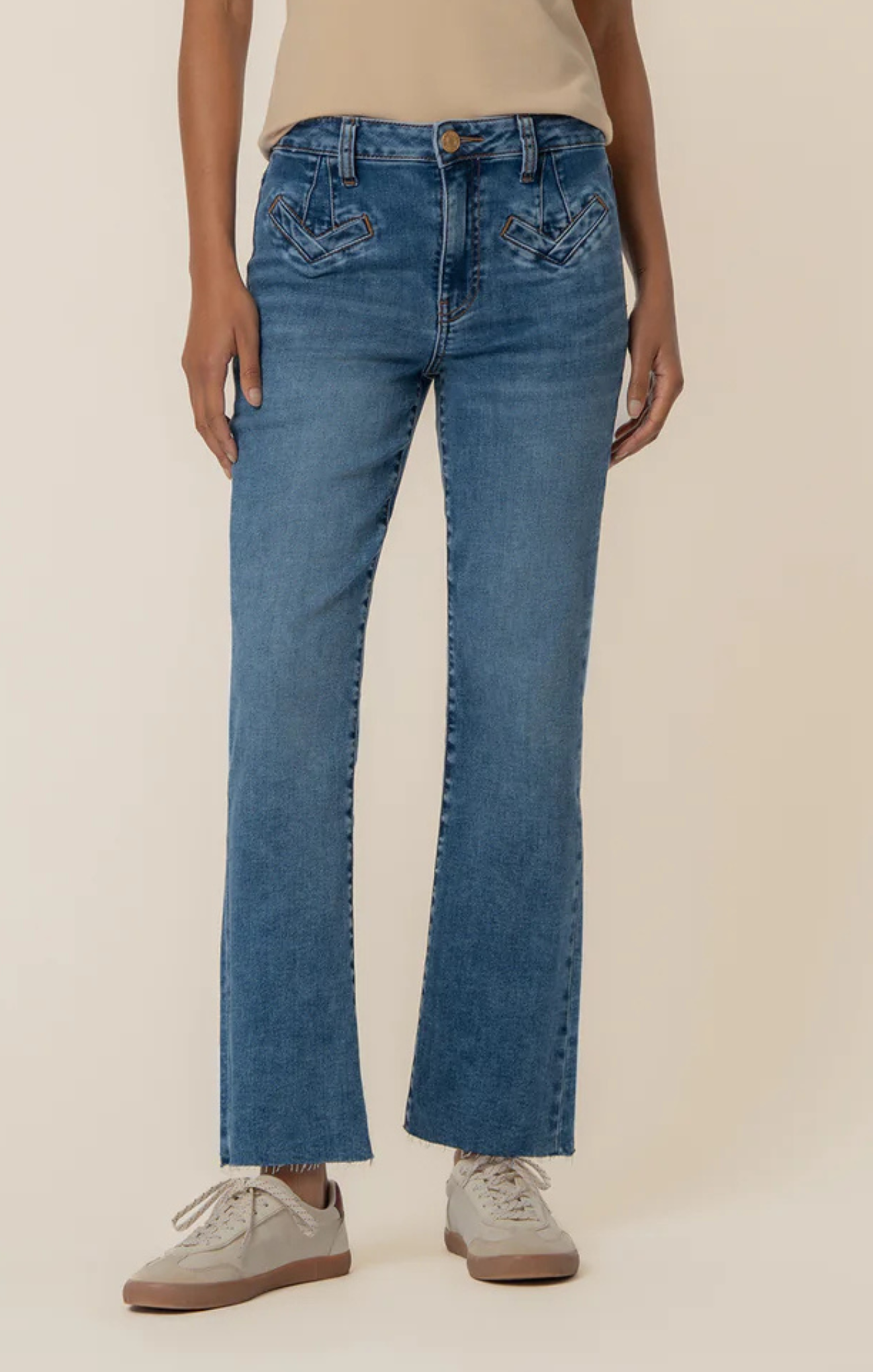 Person wearing blue jeans on a beige background