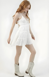 Woman wearing a white dress and white boots on a white background
