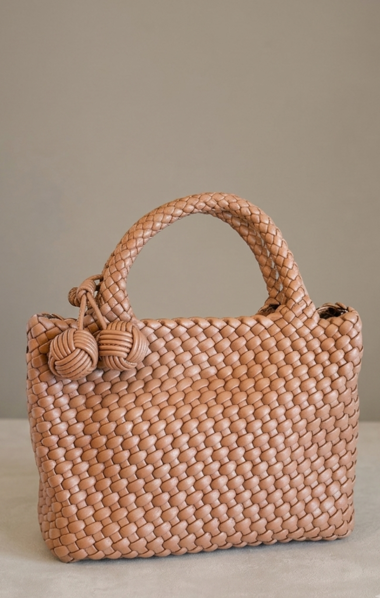 brown woven bag on neutral background