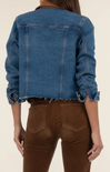 Blue denim jacket worn by a person on a beige background