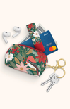 Floral-patterned pouch with earbuds, cards, and keys on a white background