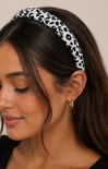 Woman wearing a leopard print headband with a neutral background