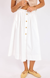 Person wearing a white skirt with gold buttons on a plain background