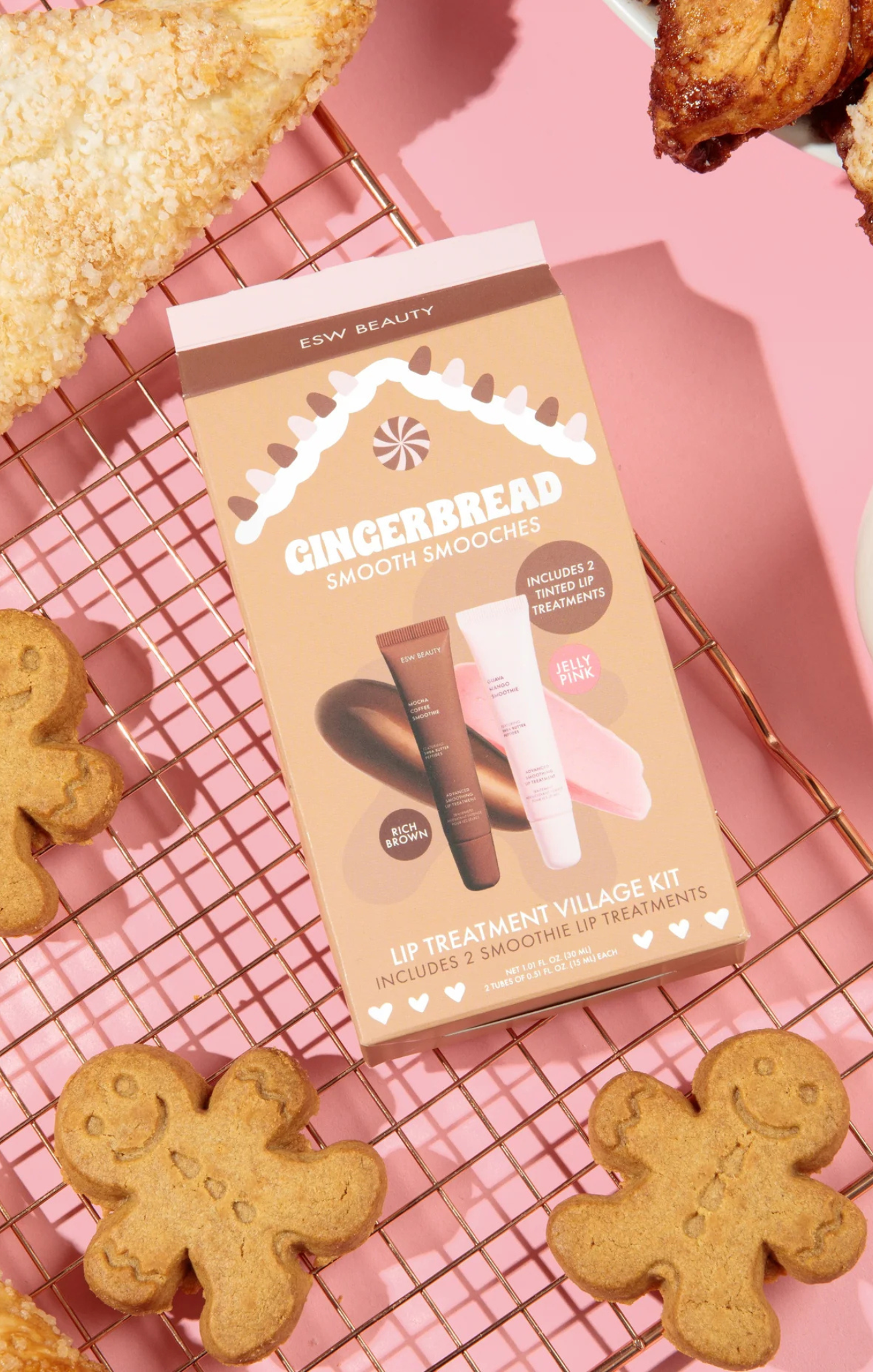 Gingerbread-themed skincare product set on a pink background with gingerbread cookies.
