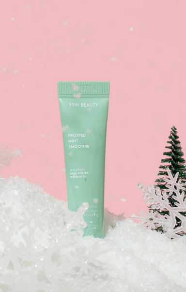 Green skincare product with 'ESW Beauty' branding on a pink background with snow-like texture
