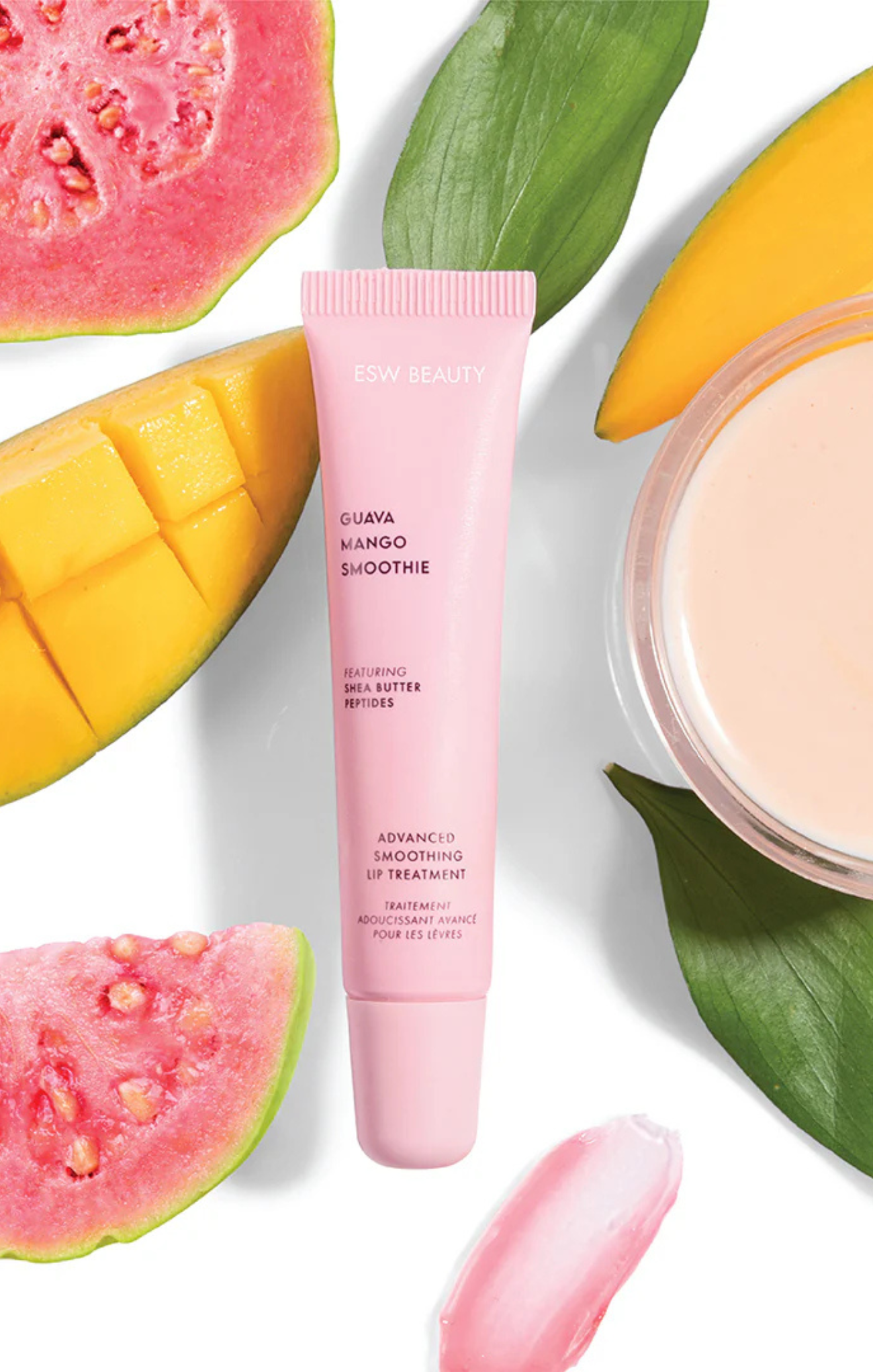 Pink skincare tube with guava, mango, and green leaves on a white background