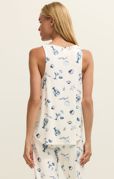 Woman wearing a sleeveless top with a blue and white pattern on a beige background