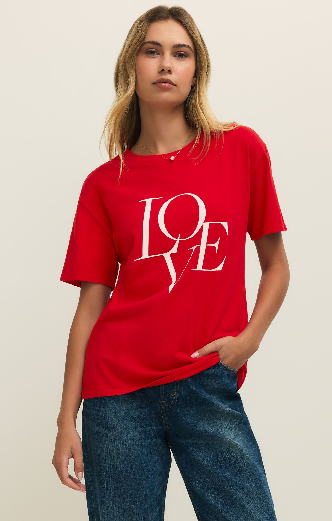 Person wearing a red t-shirt with 'LOVE' printed on it against a plain background