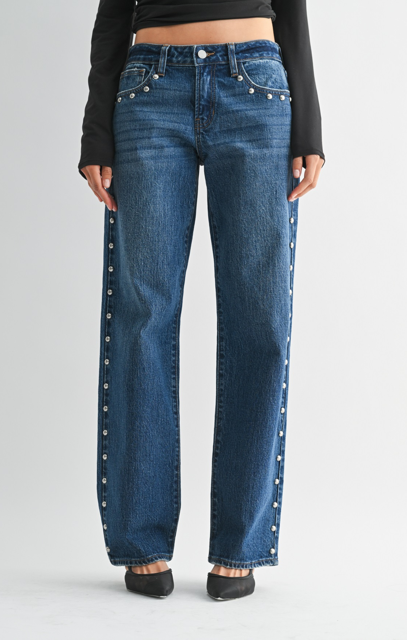 Blue jeans with decorative studs on a plain background