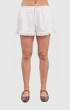 White lace-trimmed shorts worn by a person on a white background