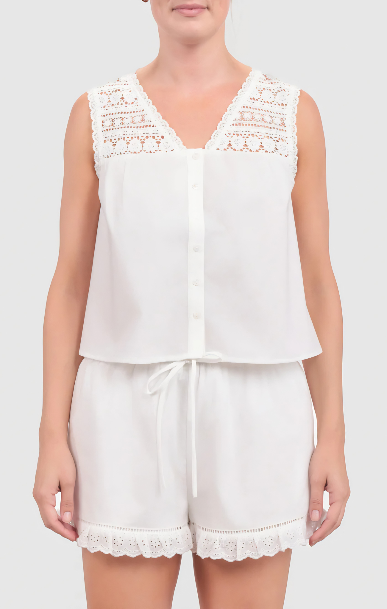 White sleeveless top and shorts set with lace details on a plain background