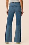 Blue flared jeans worn by a person on a beige background