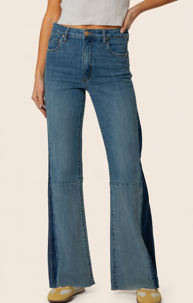 Blue flared jeans worn by a person on a beige background