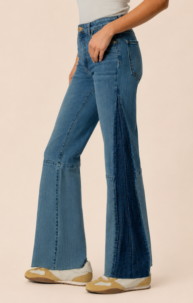 Blue flared jeans worn by a person on a beige background