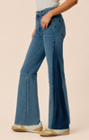 Blue flared jeans worn by a person on a beige background