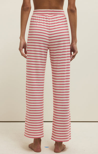 Red and white striped pants worn by a person on a beige background