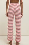 Red and white striped pants worn by a person on a beige background