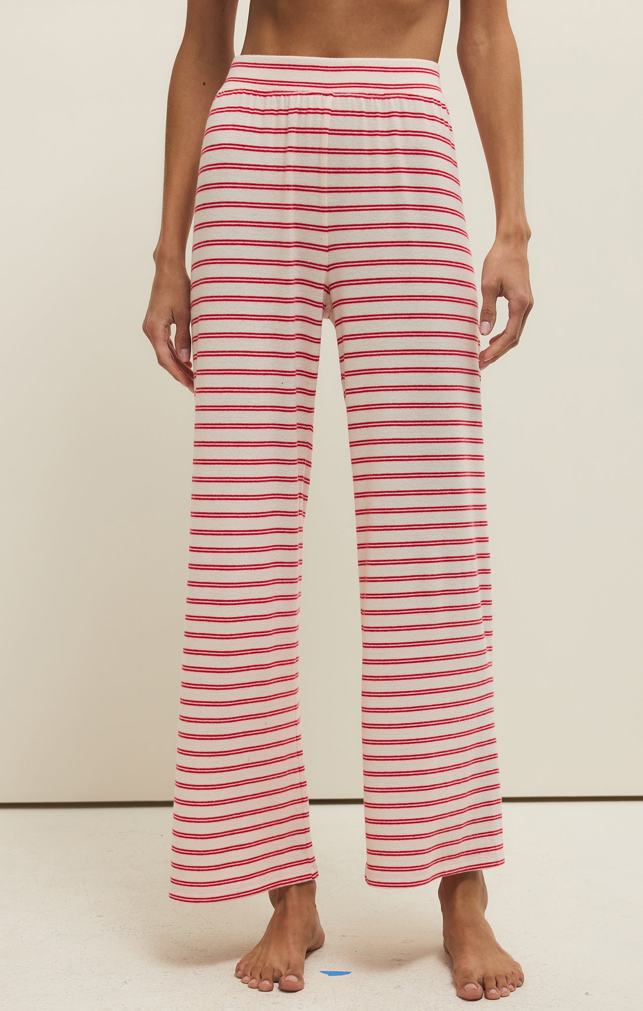 Red and white striped pants worn by a person on a neutral background