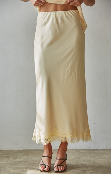 Beige skirt with lace hem worn by a person on a plain background