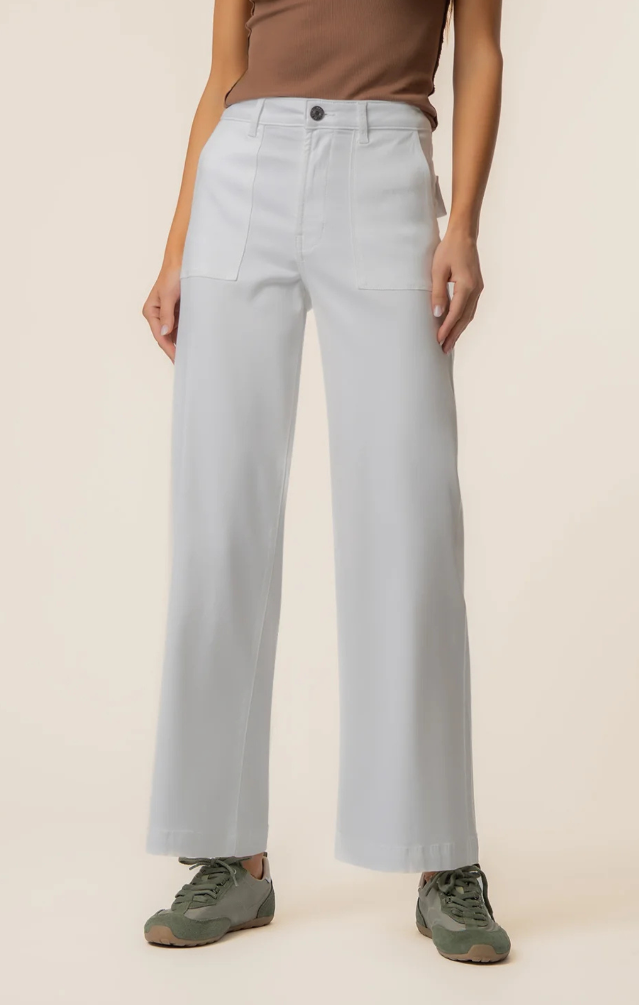 Light blue jeans worn by a person on a beige background