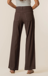 Brown wide-leg pants worn by a person on a beige background