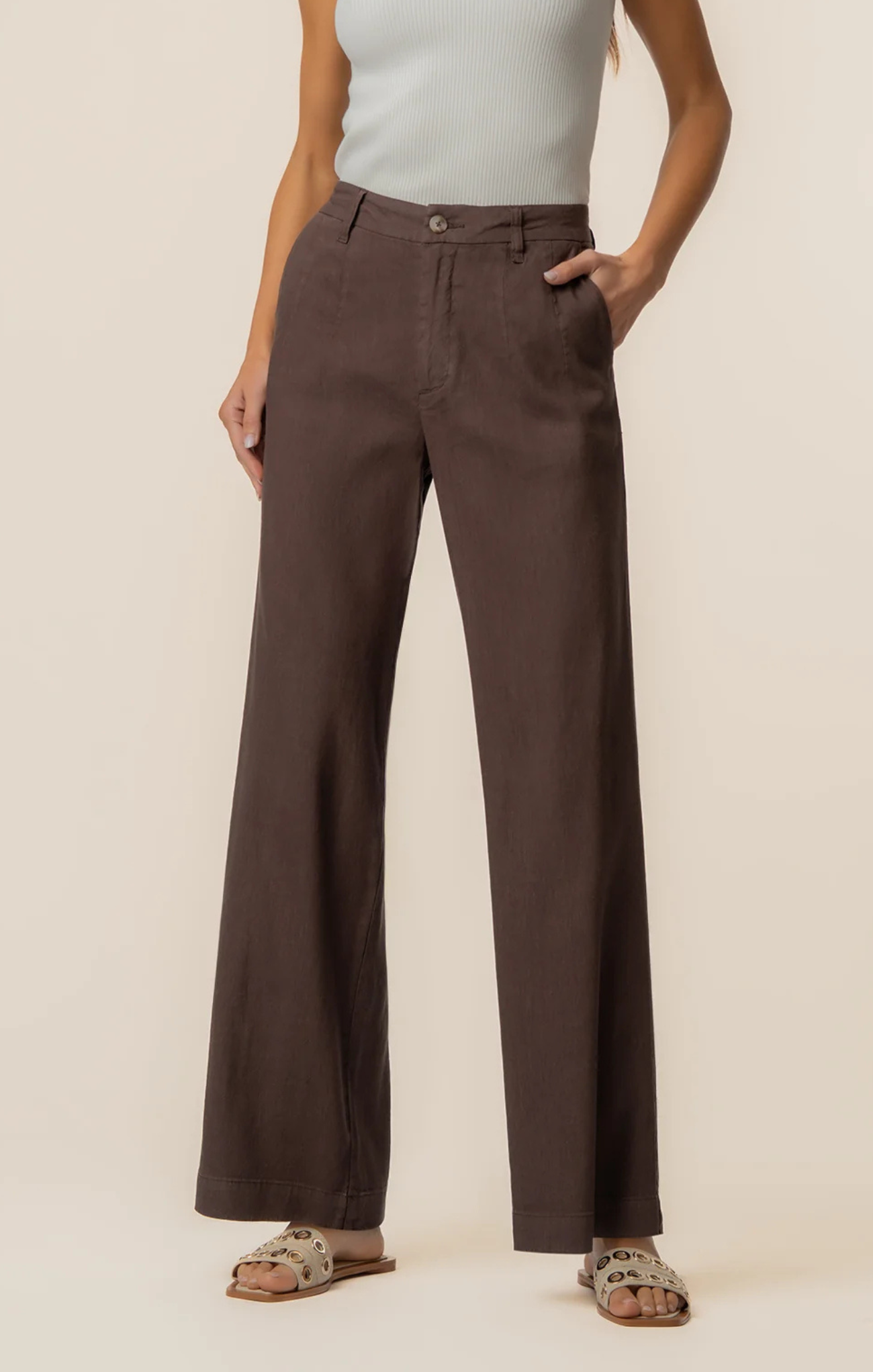 Person wearing brown pants on a plain background