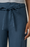 Navy blue pants with a tie waist worn by a person on a neutral background