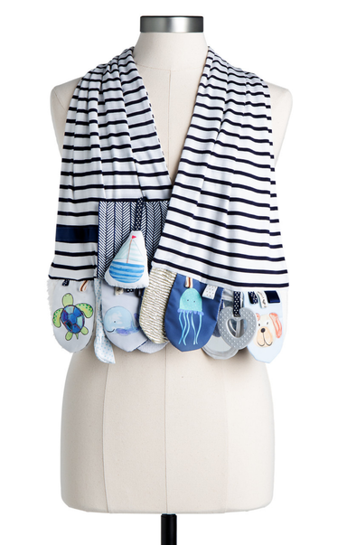 Striped baby blanket with toy pouches on a mannequin against a white background