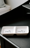 white glass dish on black counter with mr and mrs on dish
