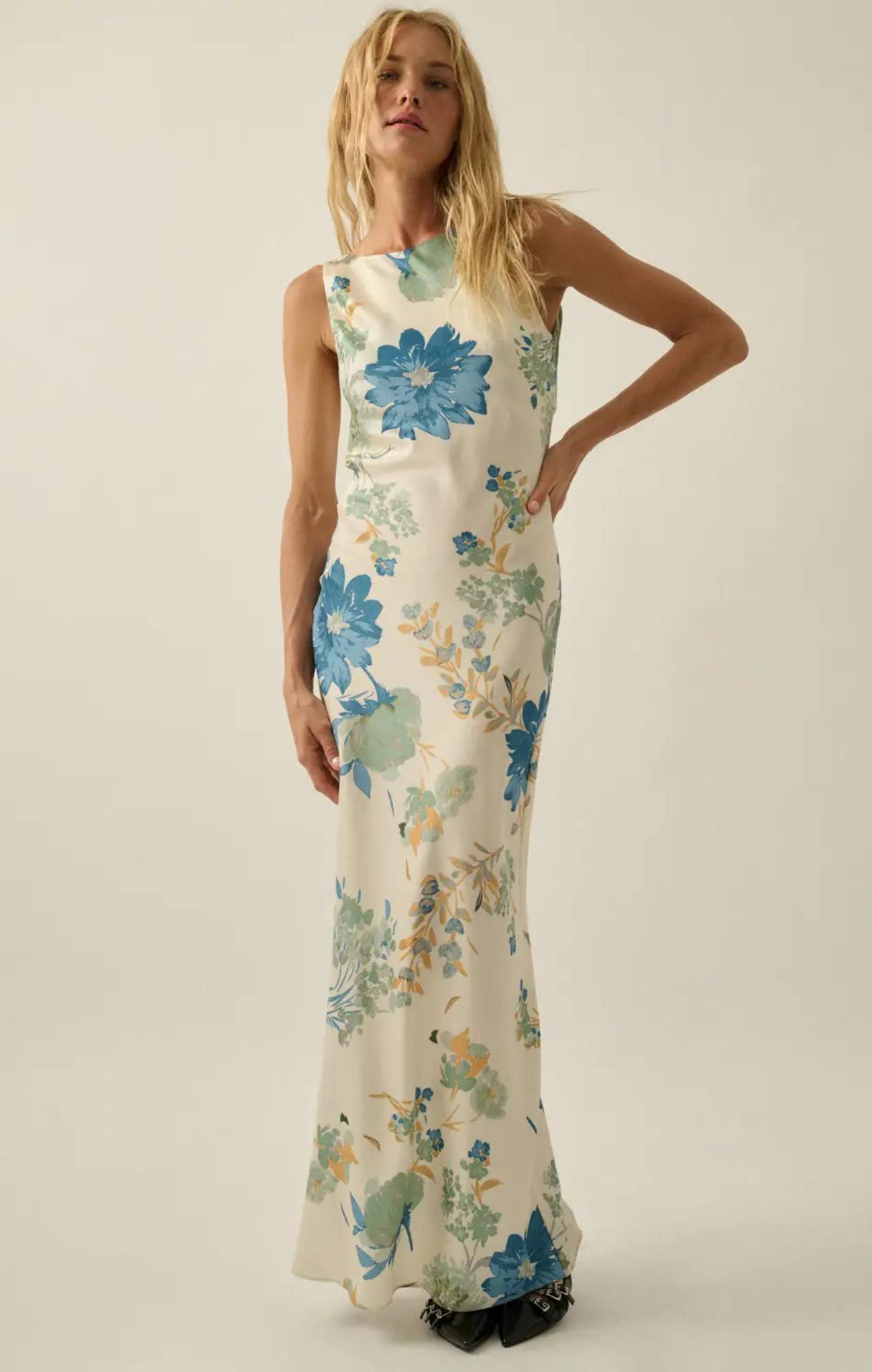 Woman wearing a floral dress with blue flowers on a plain background