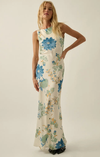 Woman wearing a floral dress with blue flowers on a plain background