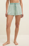 Person wearing green and white striped shorts on a beige background