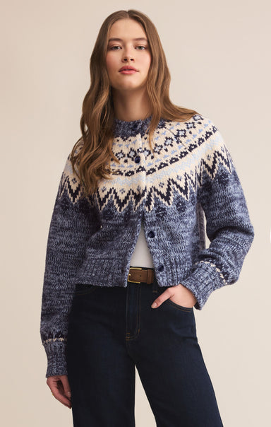 Woman wearing a blue and white patterned sweater against a beige background