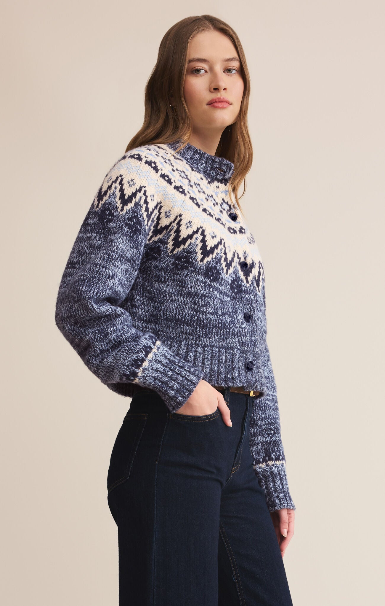 Woman wearing a patterned sweater against a plain background