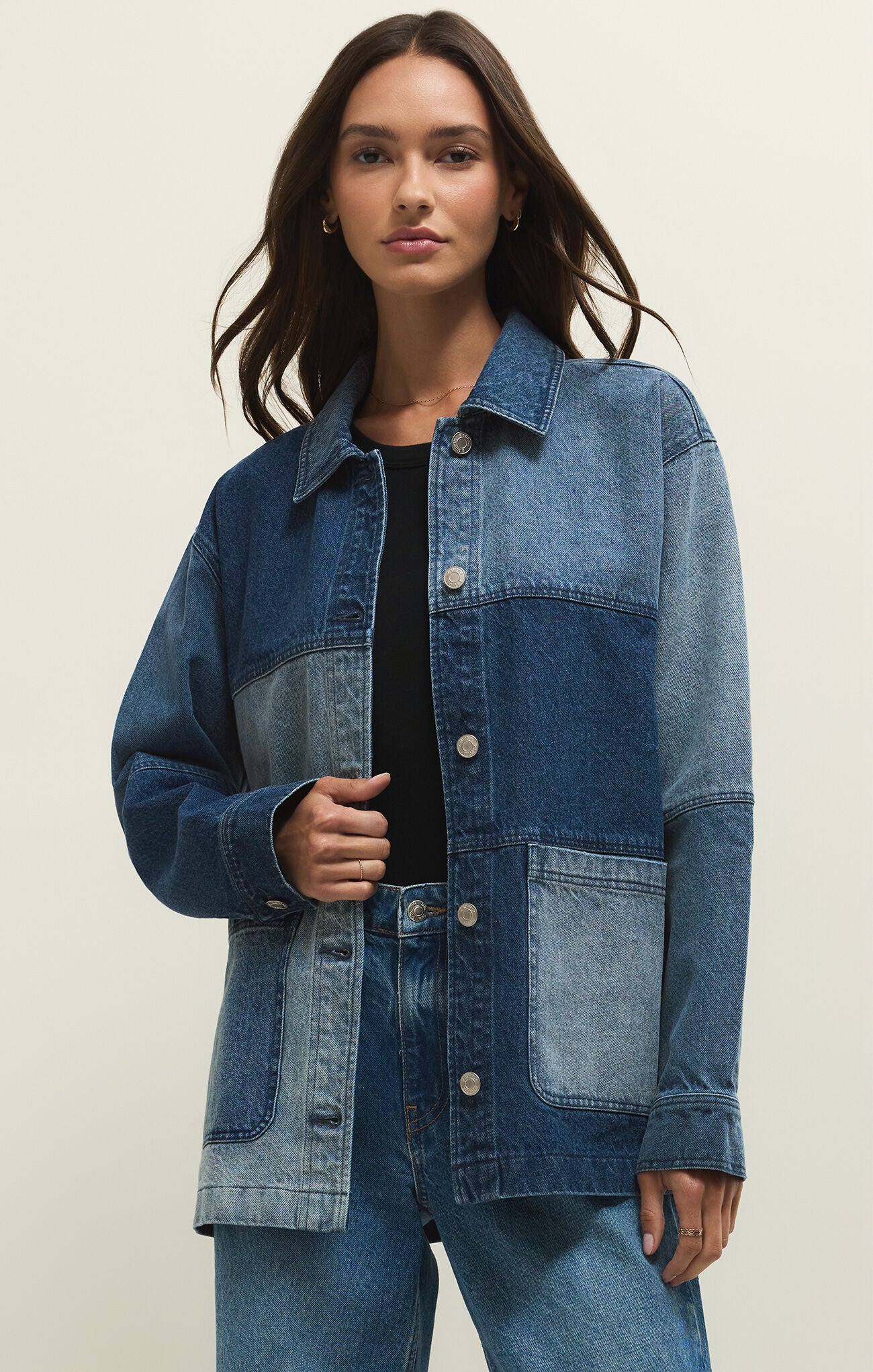 Woman wearing a blue denim jacket on a beige background