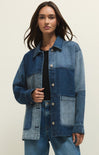 Woman wearing a blue denim jacket on a beige background