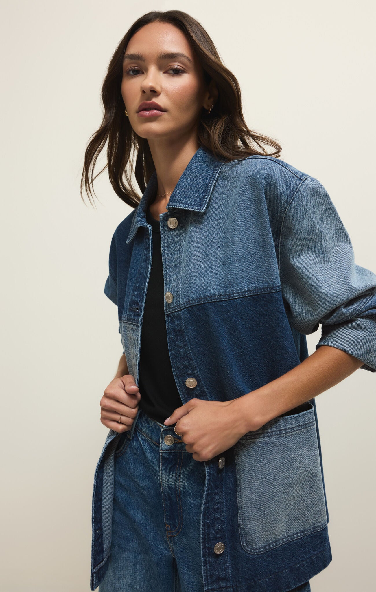 Woman wearing a denim jacket on a plain background