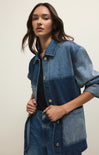 Woman wearing a denim jacket on a plain background