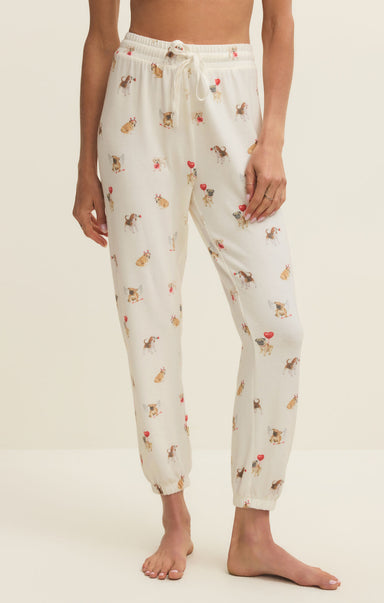 White pajama pants with animal print worn by a person on a beige background